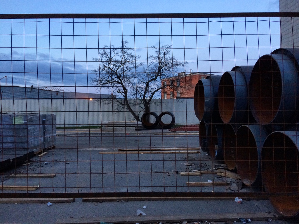 Photo of a lumber supply yard through a fence.