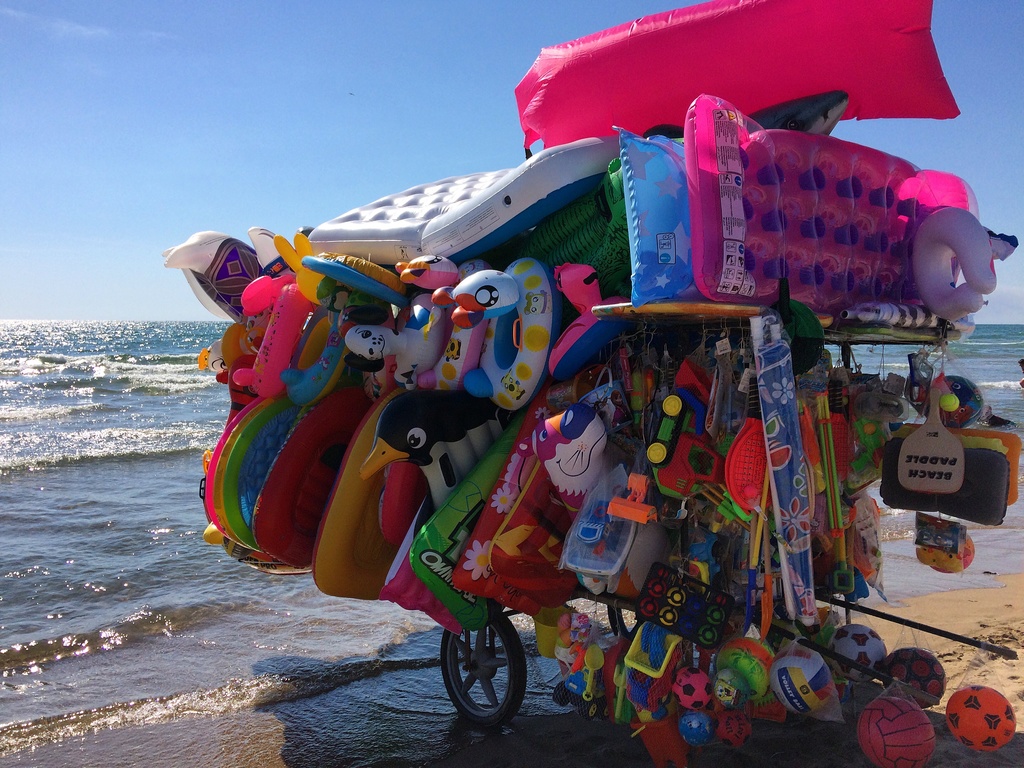 Photo of a beach bike selling beach floats along the shoreline.