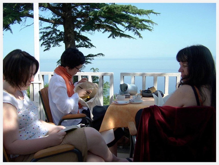 writers talking at a table next to the ocean