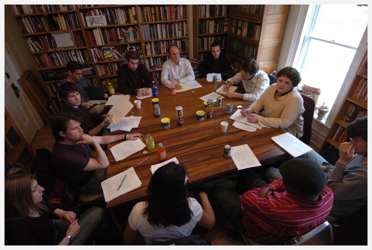 group of people sitting around a table discussing writing