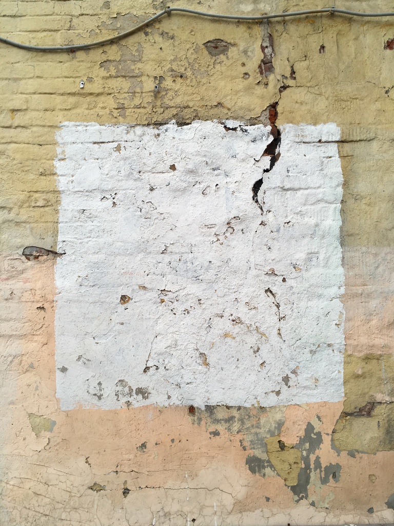 Photo of a white square on a painted brick building.