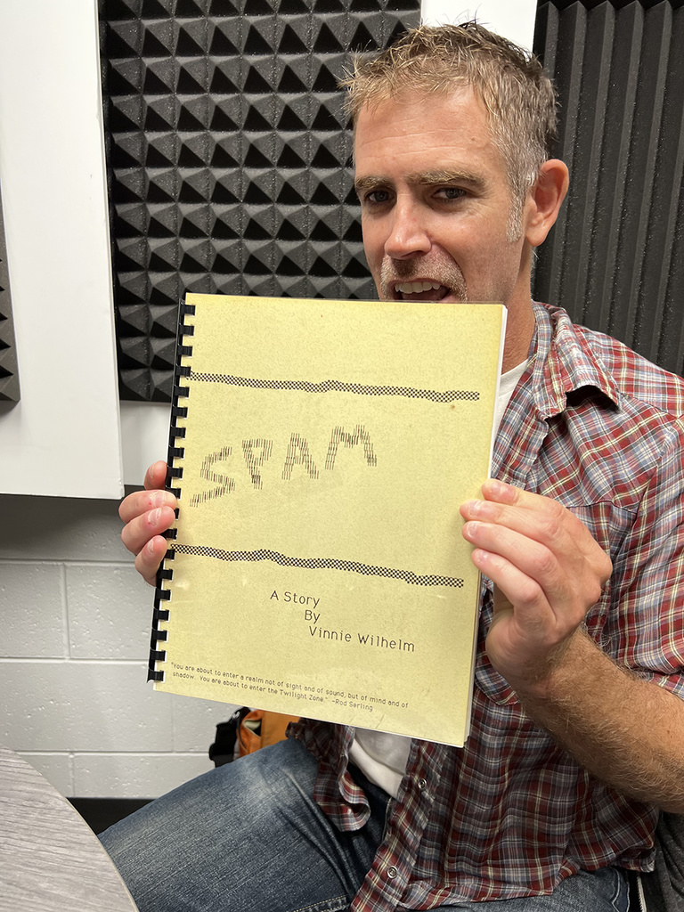 vinnie holding up his bound story "SPAM"