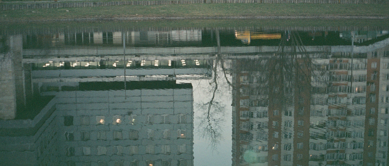 Reflection of industrial buildings in a pond.