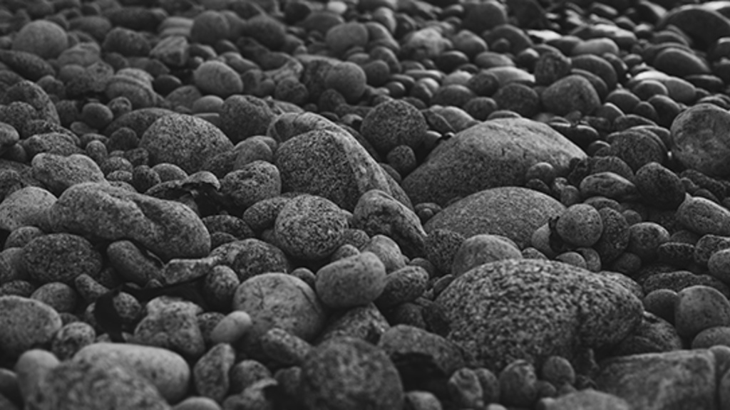 black and white photo of wet river rock and peebles 