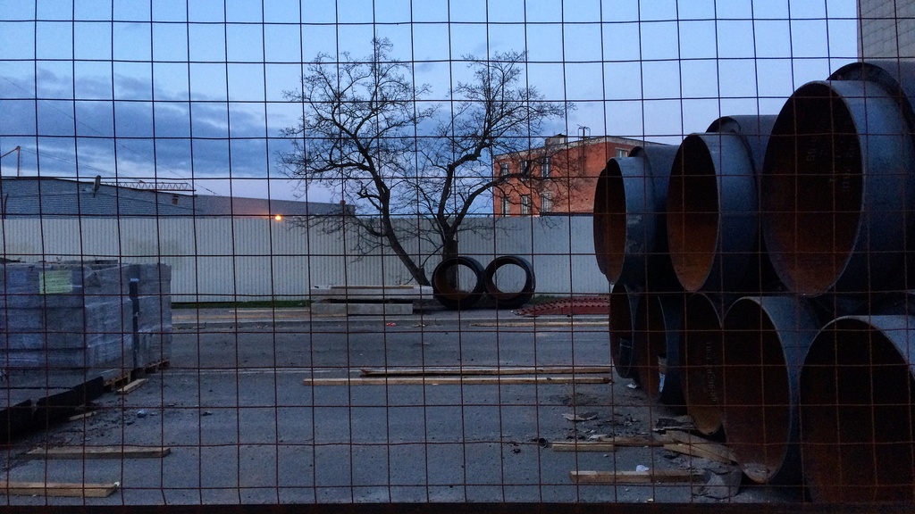 Photo of a lumber supply yard through a fence.