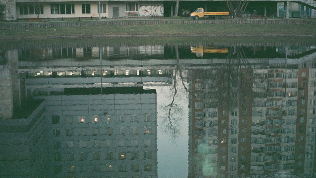 Reflection of industrial buildings in a pond.